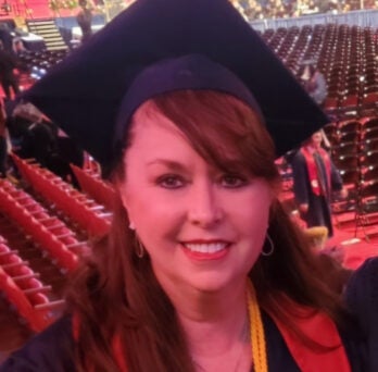 UIC RN to BSN alumna Sandra Ann Kline smiles in cap and gown 